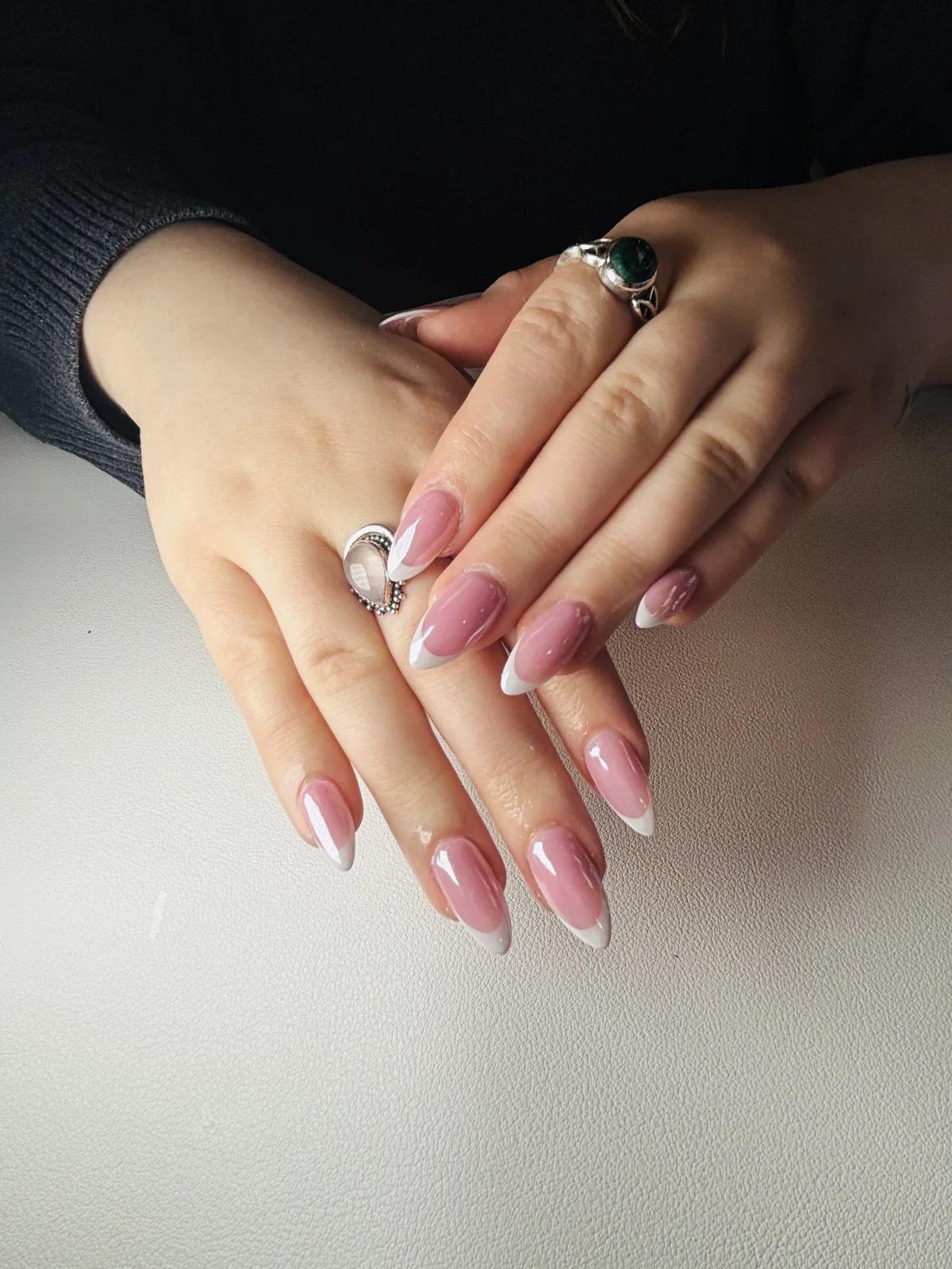 Long blush almond nails with delicate petal accents by Top Ten Nails Spa